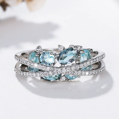 Ring met kruis en blauwe edelsteen in wit goud