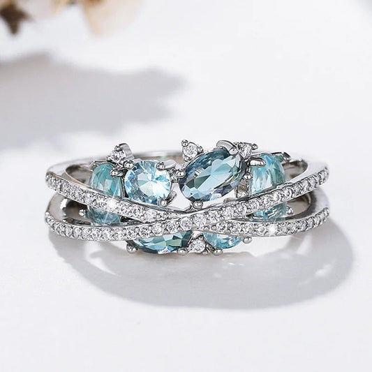 Ring met kruis en blauwe edelsteen in wit goud