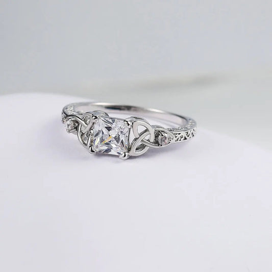Ring met strikdesign en edelsteen in het midden in goud