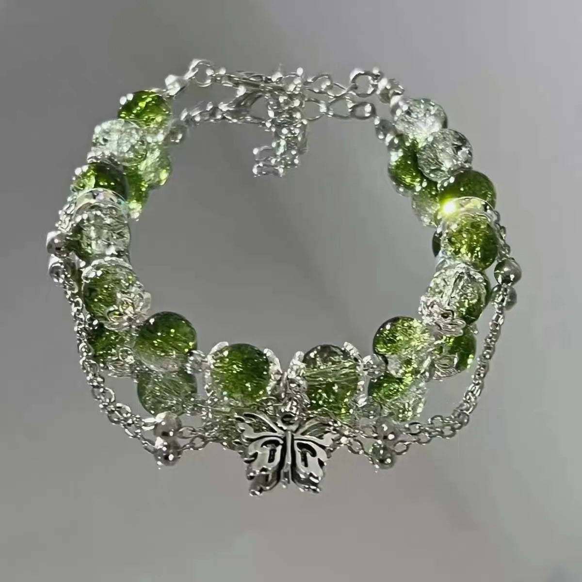 Retro armband met vlinder en groene parels in wit goud