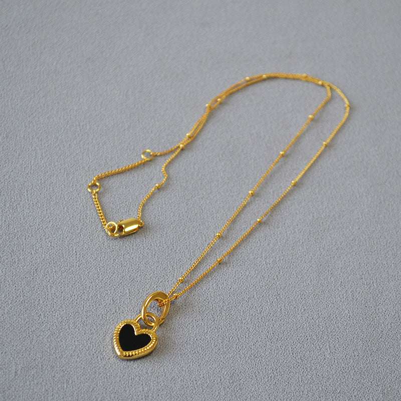 Ketting met zwart-witte harthanger in goud
